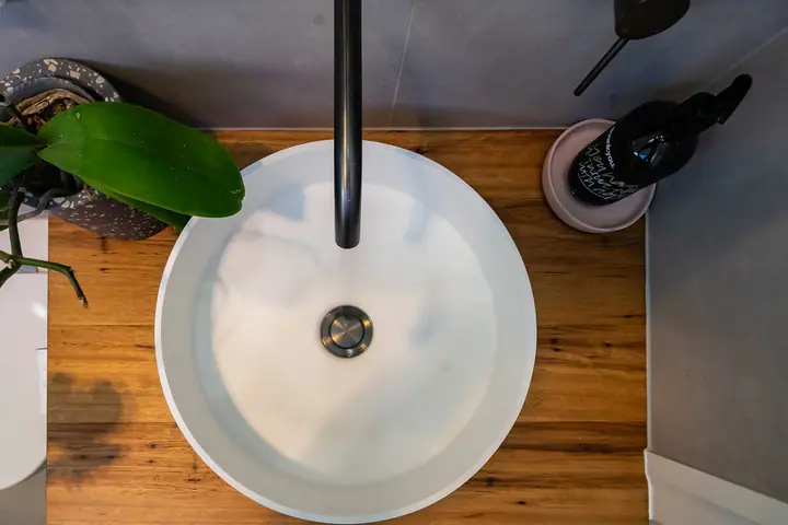 Looking down on a round basin set into a timber benchtop